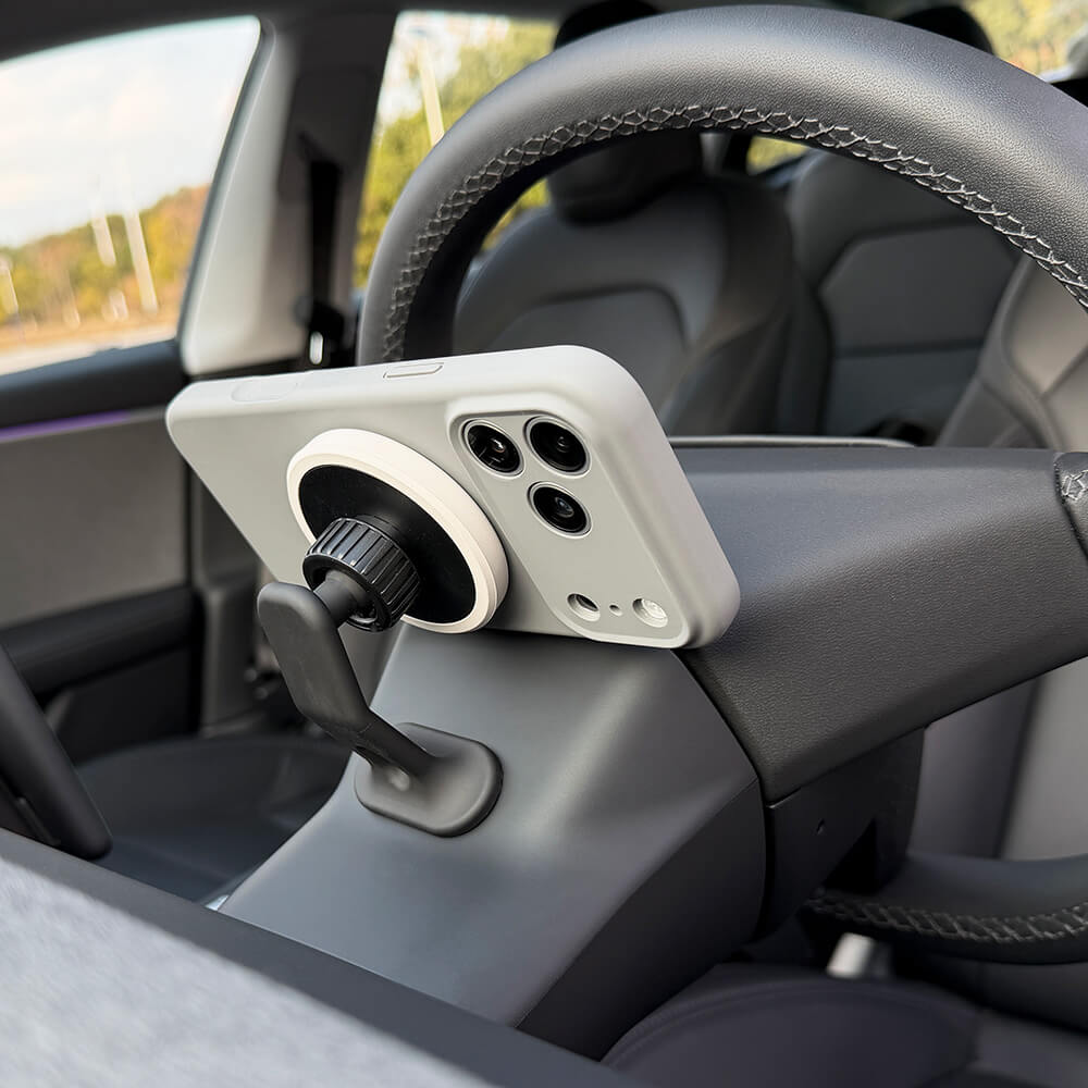 Tesla magnetic phone holder mounted behind steering wheel housing
