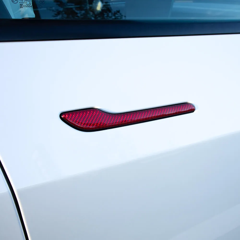 Red carbon fiber door handle trim installed on Tesla Model 3